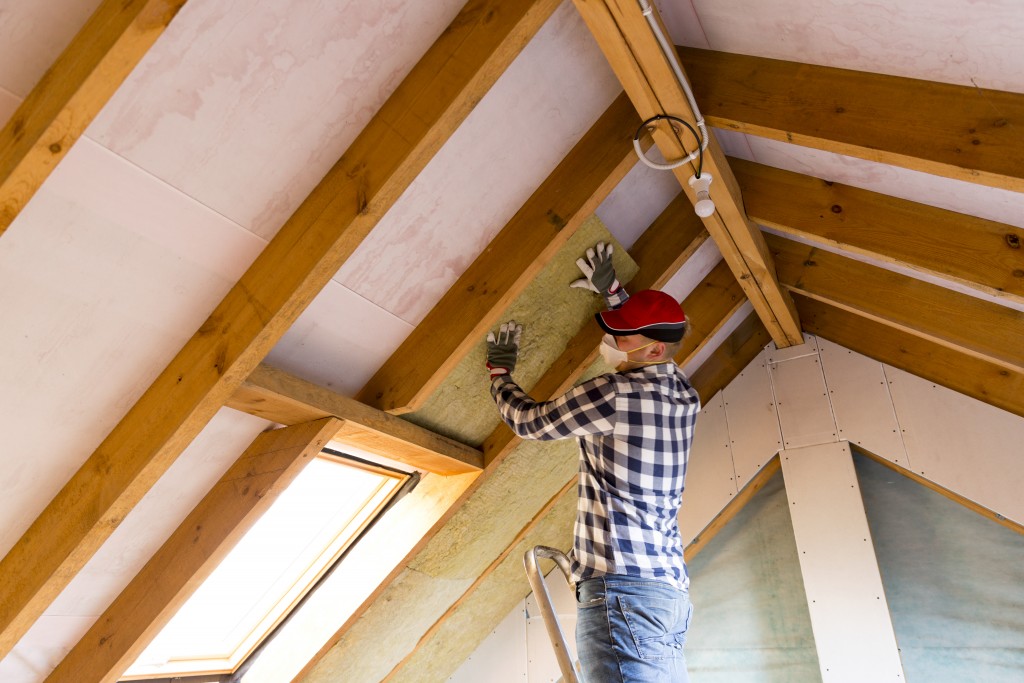 Contractor installing insulation at the roof