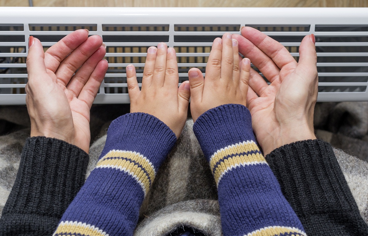 Mother and son using heater