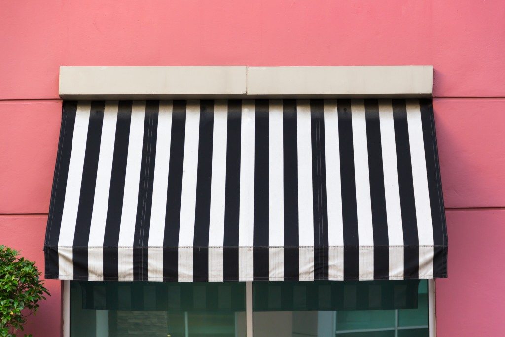 black and white Awning over glass window on pink wall