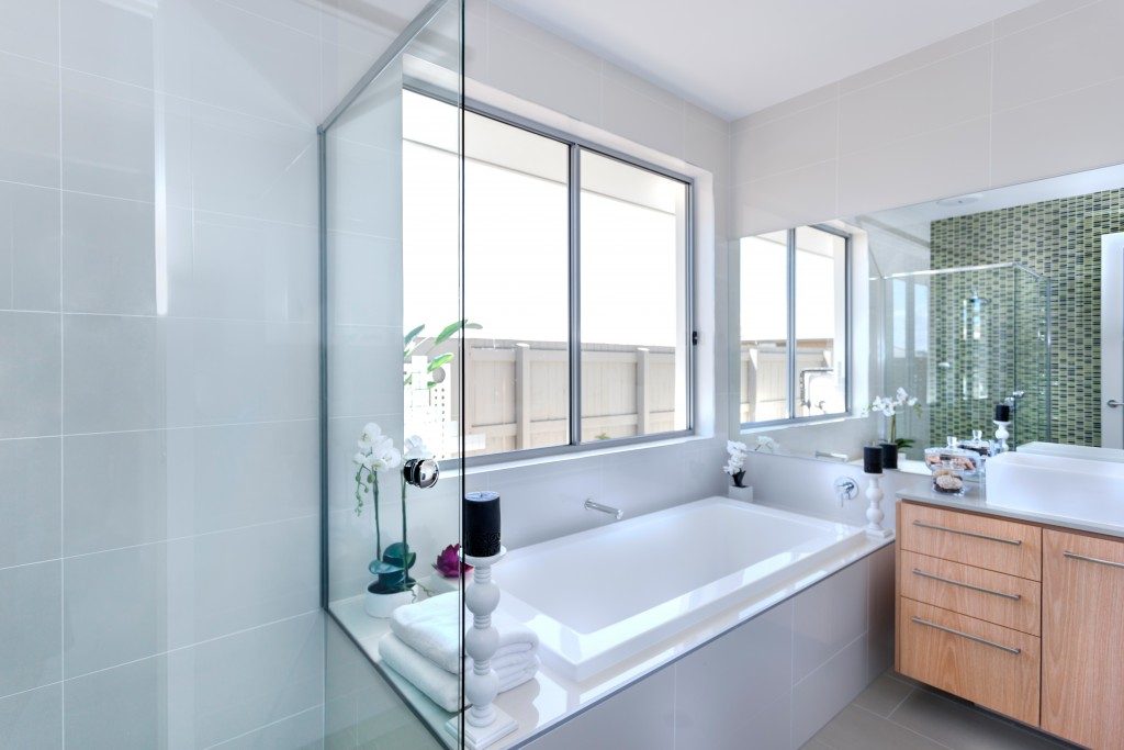 Bathroom with bathtub and large windows
