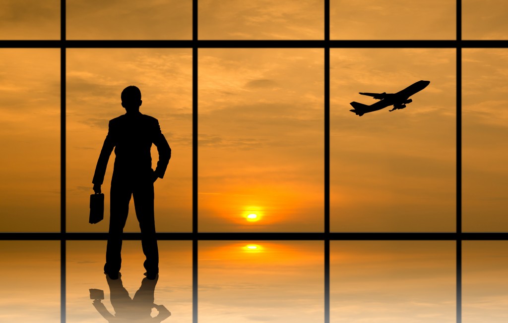 businessman in the airport on his way to his flight overseeing the sunrise