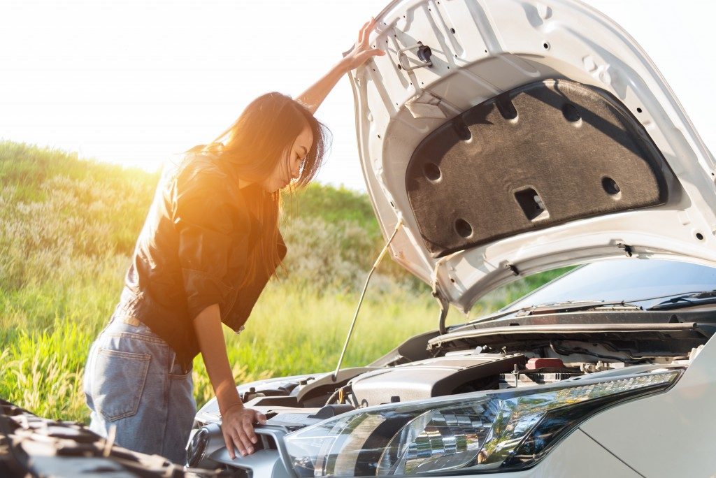 woman checking engine of her car