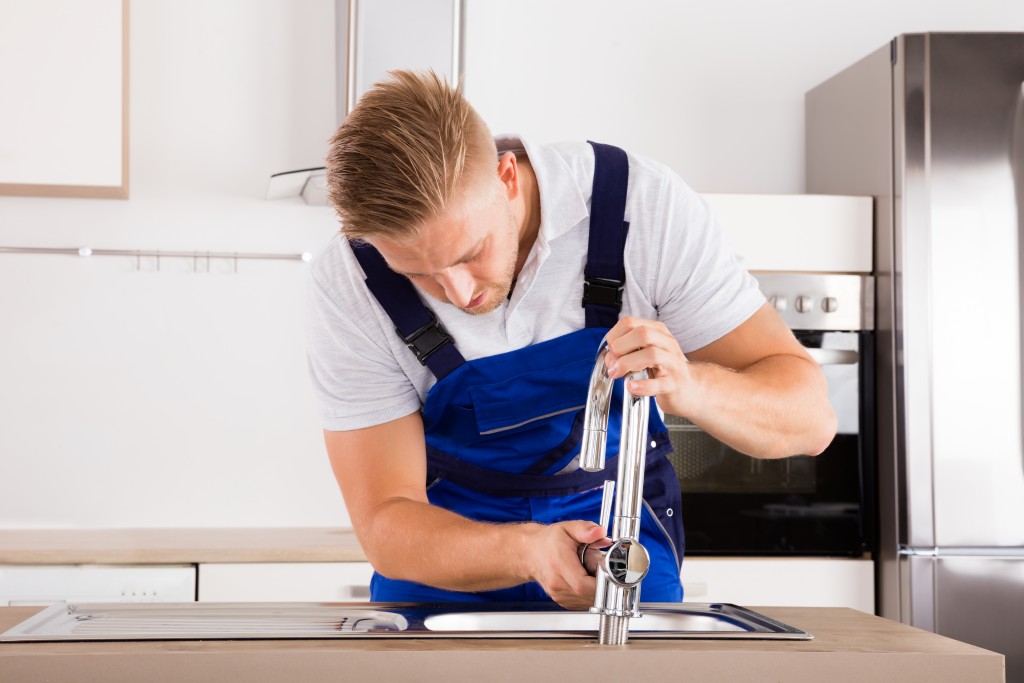 man repairing faucet