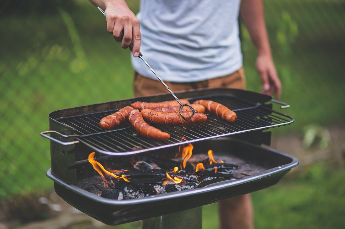 man grilling sausages