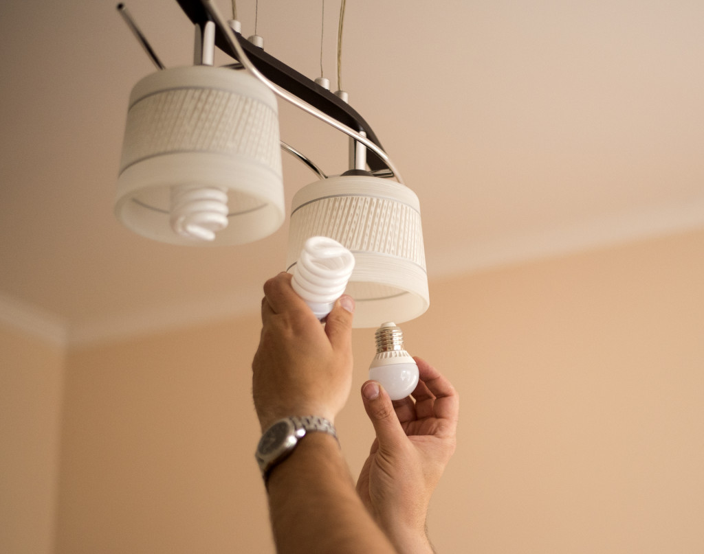 Image of a man's hands changing lightbulbs to LED