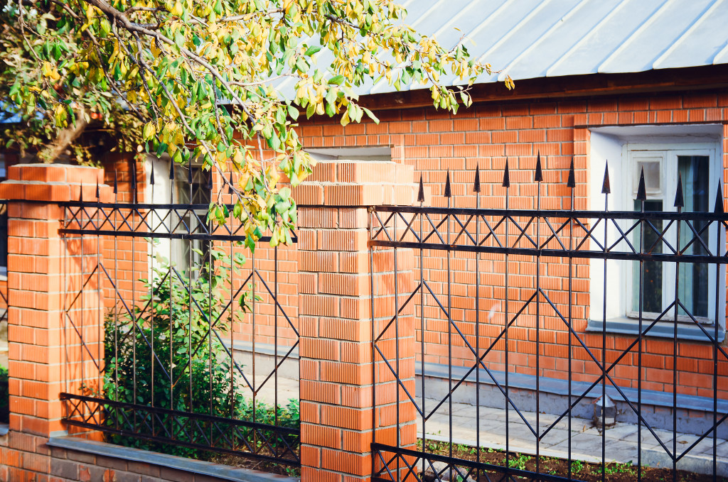 Black iron fences around a brick house