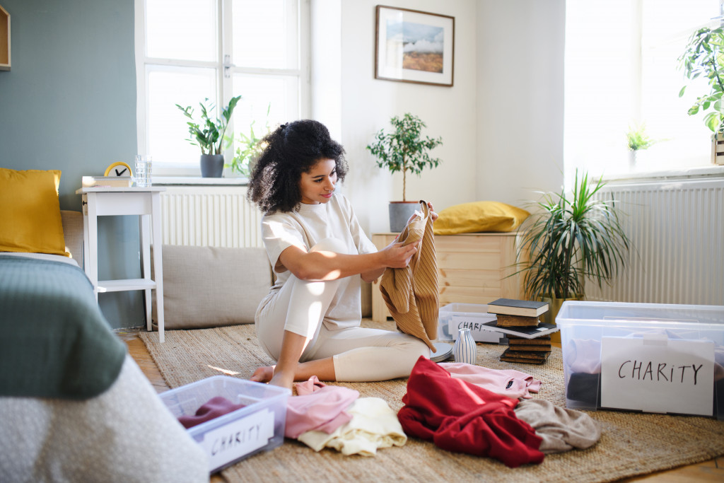 A woman sorting clothes for keeping and for charity